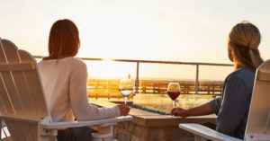 image of two people drinking wine and watching a sunset.